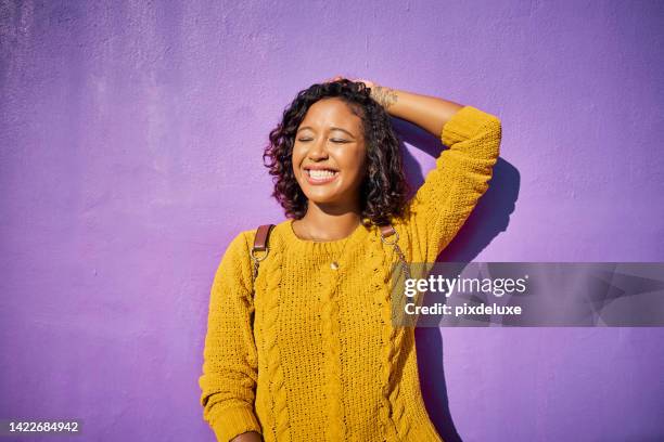 woman, purple and arm wall pose for cute and quirky color picture of attractive black lady. eyes closed, happiness and casual smiling girl stands with isolated background in outdoor location. - woman smiling eyes closed stock pictures, royalty-free photos & images