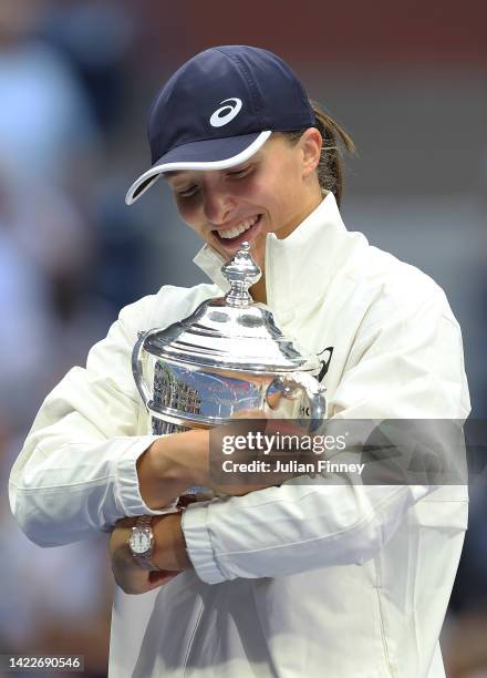 Iga Swiatek of Poland celebrates with the championship trophy after defeating Ons Jabeur of Tunisia during their Women’s Singles Final match on Day...