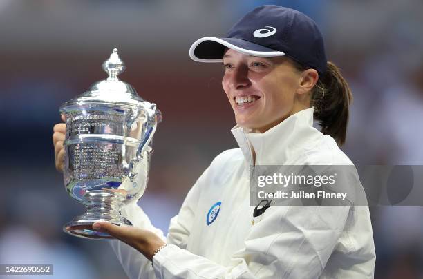 Iga Swiatek of Poland celebrates with the championship trophy after defeating Ons Jabeur of Tunisia during their Women’s Singles Final match on Day...