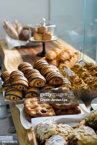 freshly baked food in display cabinet at cafe - boulangerie vitrine stockfoto's en -beelden