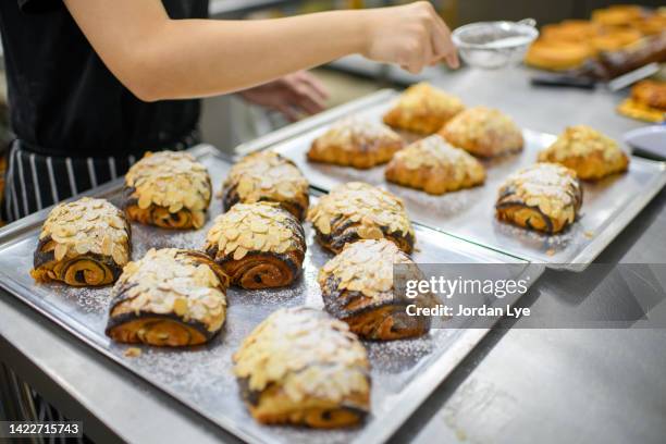 sprinkling sugar powder on danish pastry - pain au chocolat stock pictures, royalty-free photos & images