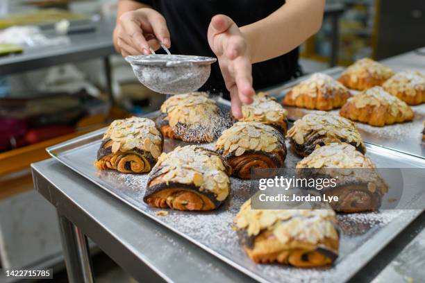 sprinkling sugar powder on danish pastry - pain au chocolat stock pictures, royalty-free photos & images