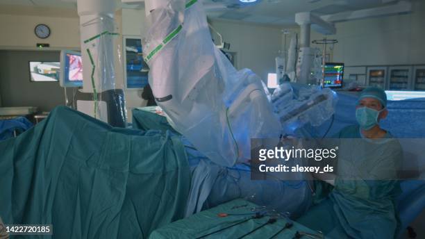 surgeon looks at the monitor during the laparoscopic operation. - surgical robot stock pictures, royalty-free photos & images