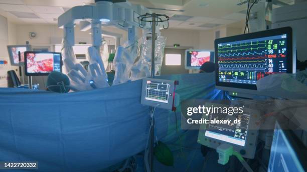 medical devices showing vital signs of a patient in an operating room where laparoscopic surgery is being done - surgical robot stock pictures, royalty-free photos & images
