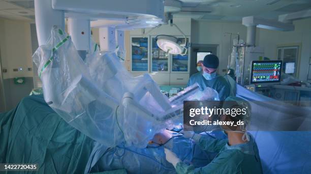 surgeon doing laparoscopic surgery in hospital with a medical robot - cirurgia robótica imagens e fotografias de stock