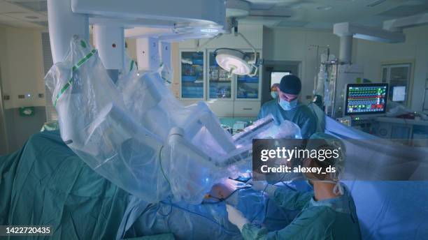 surgeon doing laparoscopic surgery in hospital with a medical robot - laparoscopy 個照片及圖片檔