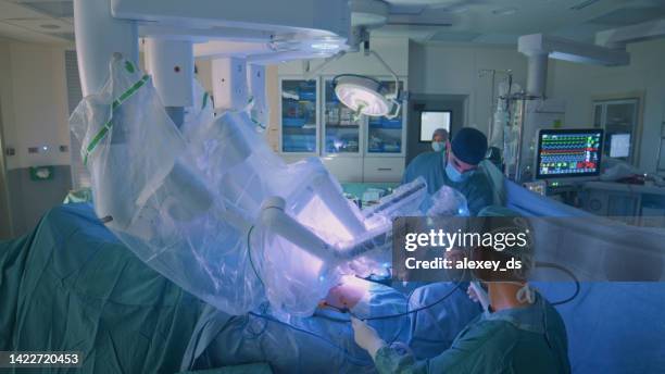 surgeon doing laparoscopic surgery in hospital with a medical robot - robot surgery stock pictures, royalty-free photos & images