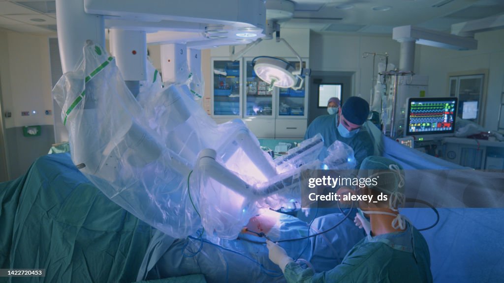 Surgeon doing laparoscopic surgery in hospital with a medical robot