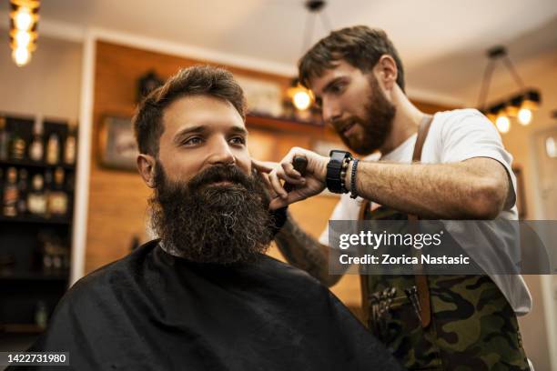 young barber working - man cutting wire stockfoto's en -beelden