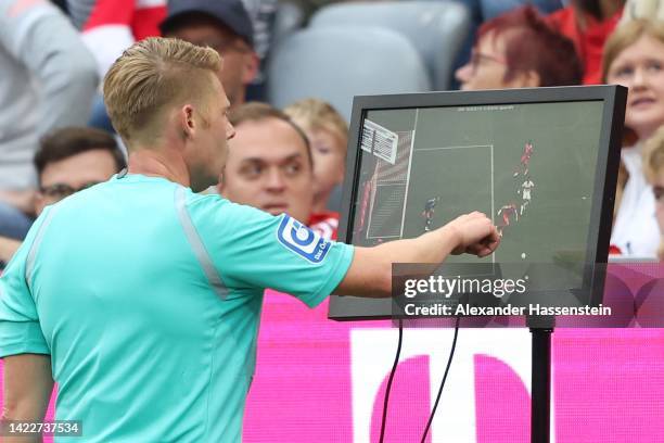 Referee Christian Dingert checks the VAR screen during the Bundesliga match between FC Bayern München and VfB Stuttgart at Allianz Arena on September...