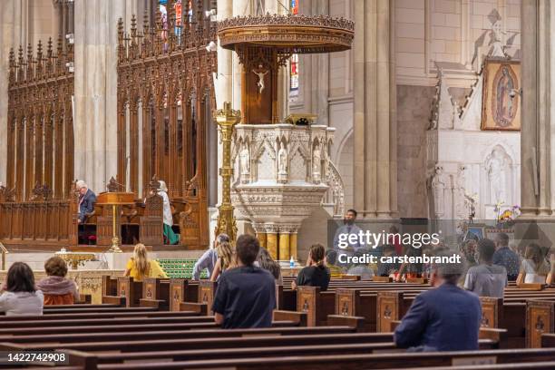 priest celebrating mass in front of the pulpit - prayer meeting stock pictures, royalty-free photos & images