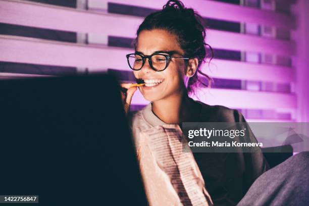 woman watching movie on laptop and eating nachos the night. - publicity event stock pictures, royalty-free photos & images