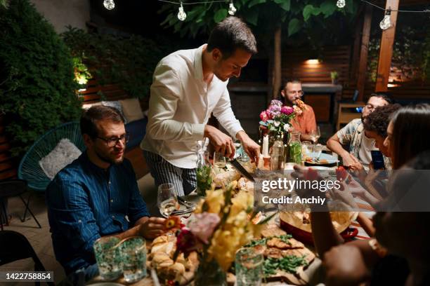 friends talking and dining outside on a warm summers evening. - al fresco dining stock pictures, royalty-free photos & images