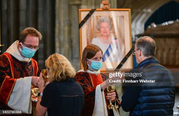 Canon Anna Macham, Precentor of Salisbury Cathedral gives communion during A Service of Holy Communion in memory of Her Majesty Queen Elizabeth II at...