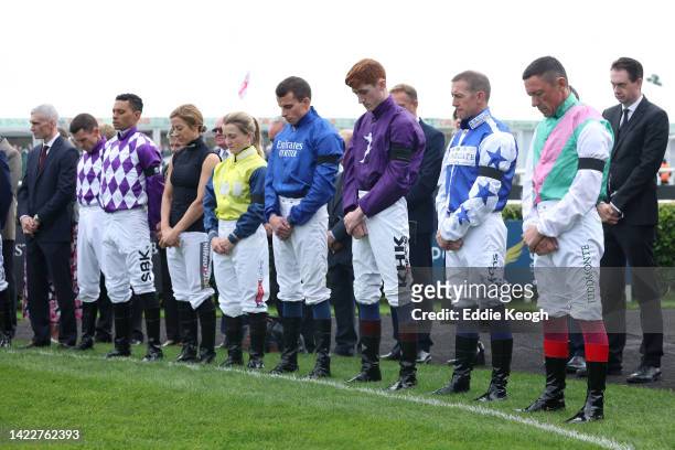 Jockeys observe a two minutes silence as they pay tribute to Her Majesty Queen Elizabeth II, who died away at Balmoral Castle on September 8, 2022 at...