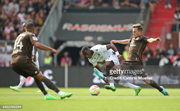 Johannes Eggestein of FC St. Pauli is challenged by Merveille Papela of SV Sandhausen during the Second Bundesliga match between FC St. Pauli and SV...