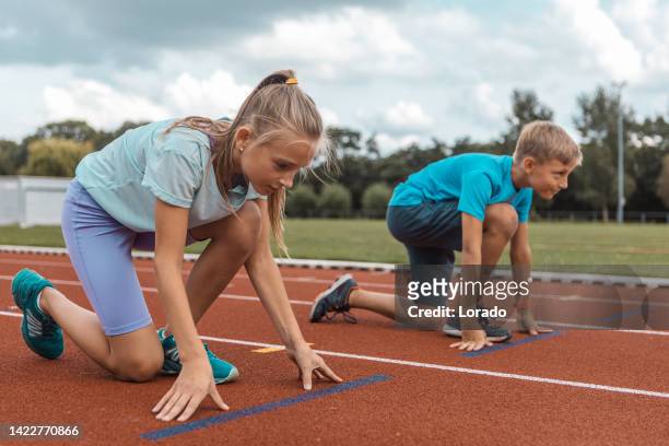 two athletic children working hard on the running track - running netherlands stock pictures, royalty-free photos & images