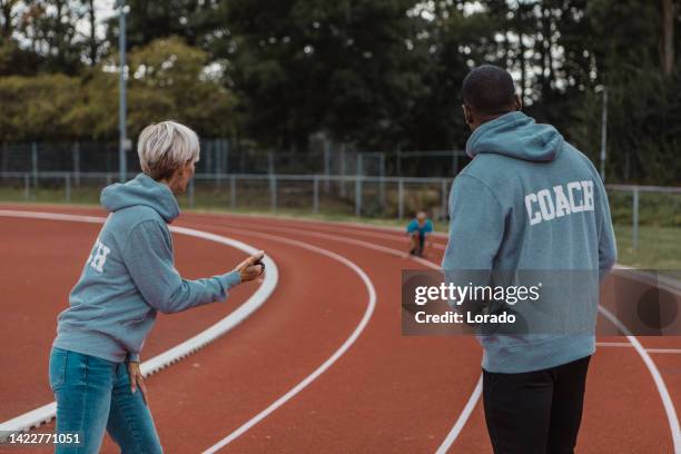 athletics mother running coach working with her children during a training session - running coach stock pictures, royalty-free photos & images