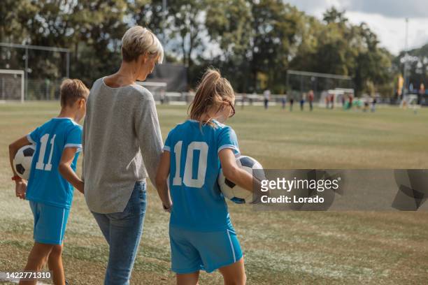 soccer mother football coach with her children during a training session - soccer mom stock pictures, royalty-free photos & images