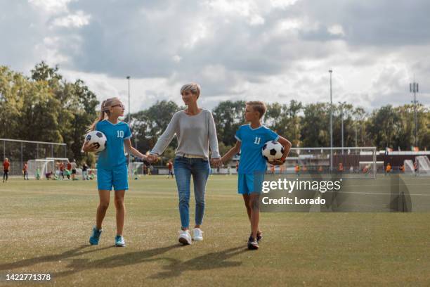 soccer mother football coach with her children during a training session - soccer mom stock pictures, royalty-free photos & images