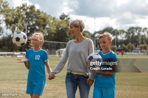 soccer mother football coach with her children during a training session - soccer mom stock pictures, royalty-free photos & images