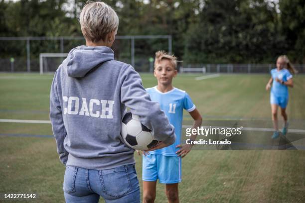 fußballmutter fußballtrainerin mit ihren kindern während einer trainingseinheit - soccer mum stock-fotos und bilder