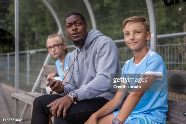 soccer football coach with two children during a training session - family football team stock pictures, royalty-free photos & images