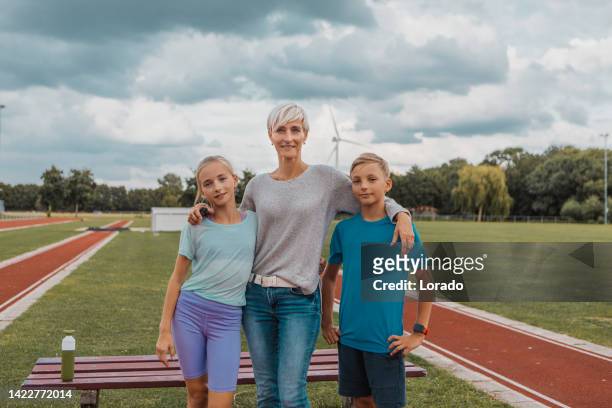 Athletics mother running coach with her children during a training session