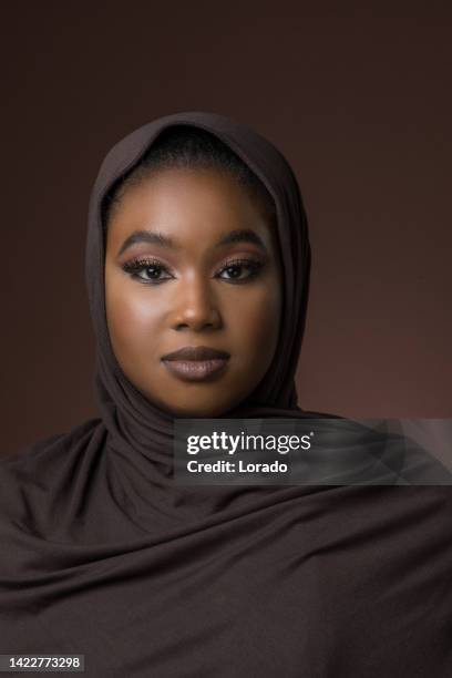 portrait of a beautiful muslim woman wearing hijab in a studio shot - arab woman studio stock pictures, royalty-free photos & images