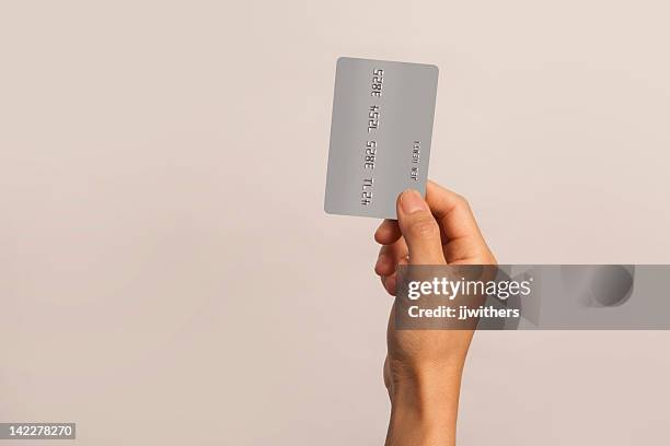 woman's hand holding falschen kreditkarte - credit card stock-fotos und bilder