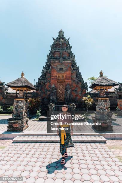 tourist in bali, batuan temple on background - balinese culture stock pictures, royalty-free photos & images