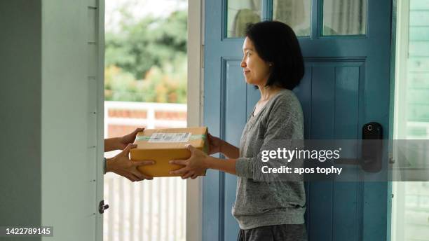 a woman recieves online shopping box - receiving parcel stock pictures, royalty-free photos & images