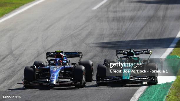 Lance Stroll of Canada driving the Aston Martin AMR22 Mercedes locks a wheel under braking as he battles for track position with Nicholas Latifi of...