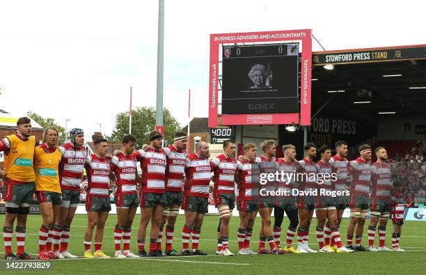 Players of Gloucester Rugby line up for a moments silence and the National Anthem as the LED Screen displays a tribute in memory of Her Majesty,...