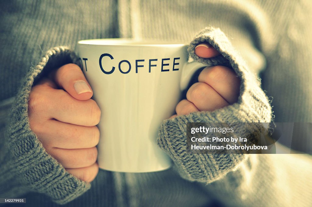 Cup of coffee in young womans hands