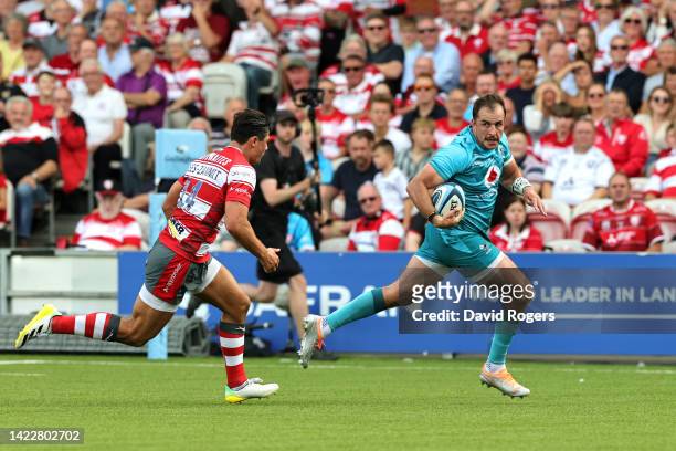 Burger Odendaal of Wasps Rugby runs in to score their side's third try whilst being chased by Louis Rees-Zammit of Gloucester Rugby during the...