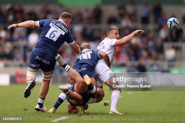 Ollie Sleightholme of Northampton Saints offloads the ball whilst under pressure from Tom O'Flaherty of Sale Sharks during the Gallagher Premiership...