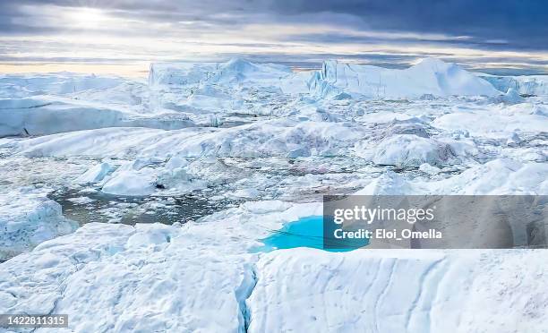 melting iceberg in the shape of a heart. climate change - jakobshavn glacier stockfoto's en -beelden