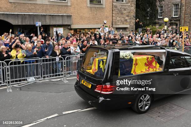 Crowds of public take photos as the Queen’s funeral cortege proceeds down The Royal Mile towards Holyroodhouse on September 11, 2022 in Edinburgh,...