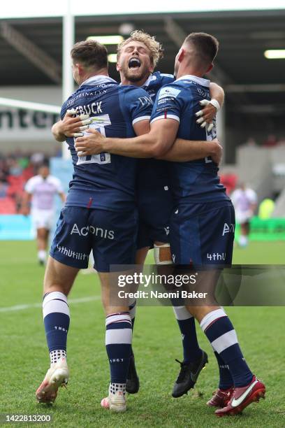 Luke James of Sale Sharks celebrates scoring their side's second try with teammates Tom Roebuck and Gus Warr during the Gallagher Premiership Rugby...