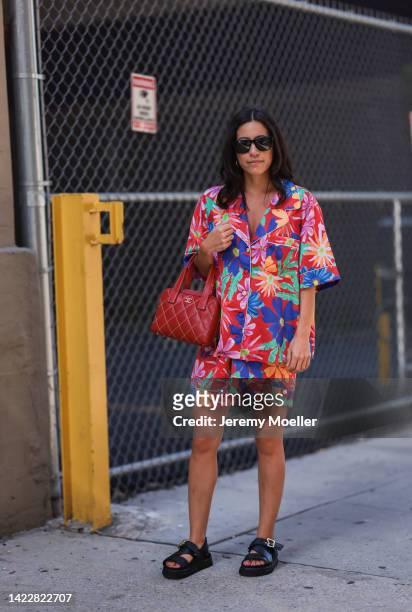 Fashion week guest is seen wearing a red Chanel bag, flower printed outfit set, black leather sandals and black sunglasses outside Altuzarra during...