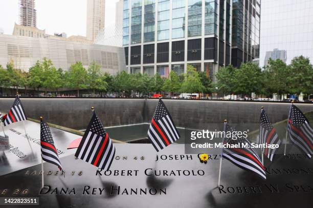 Flowers and American flags are seen on the names of victims of the 9/11 terror attack on the North Tower Memorial Pool during the annual 9/11...