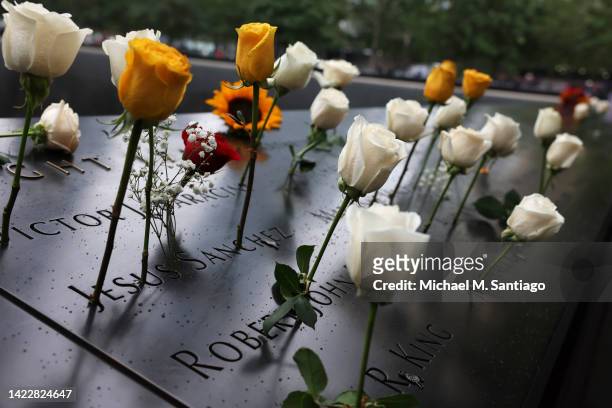 Flowers are seen on the names of the victims of the 9/11 terror attack at the North Tower Memorial Pool during the annual 9/11 Commemoration Ceremony...
