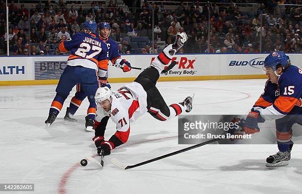 Nick Foligno of the Ottawa Senators is tripped up as he attempts to control the puck against the New York Islanders at the Nassau Veterans Memorial...