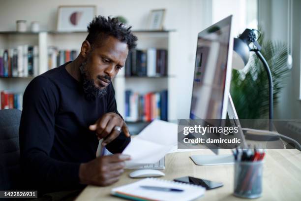 shocked man looking at monthly expensive bills - statement stockfoto's en -beelden