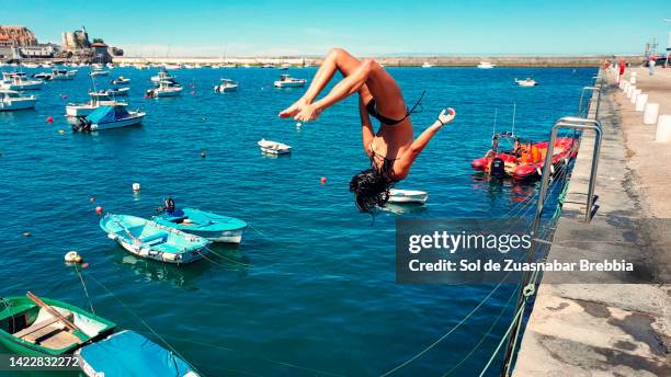 teenage girl jumping into the sea - salta argentina - fotografias e filmes do acervo