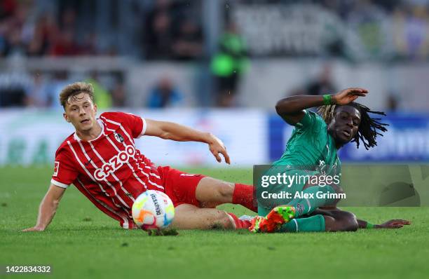 Kouadio Kone of Borussia Monchengladbach is tackled by Yannik Keitel of SC Freiburg during the Bundesliga match between Sport-Club Freiburg and...