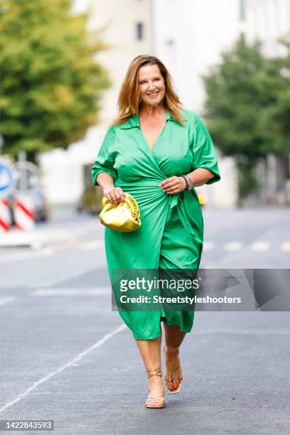 Make up artist Serena Goldenbaum, wearing a green dress by Zara, a golden bag and golden sandals by Zara, during a streetstyle shooting at Berlin...