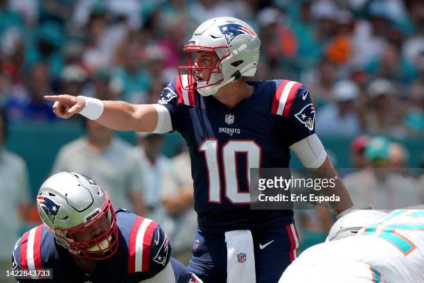Mac Jones of the New England Patriots gestures at the line of scrimmage during the first half against the Miami Dolphins at Hard Rock Stadium on...