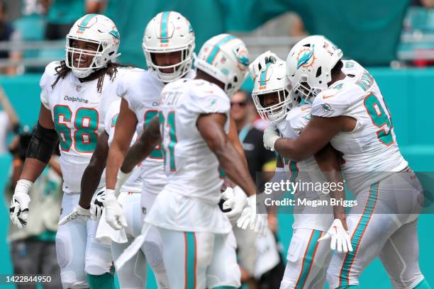 Jaylen Waddle of the Miami Dolphins celebrates with teammates after scoring a touchdown during the second quarter against the New England Patriots at...